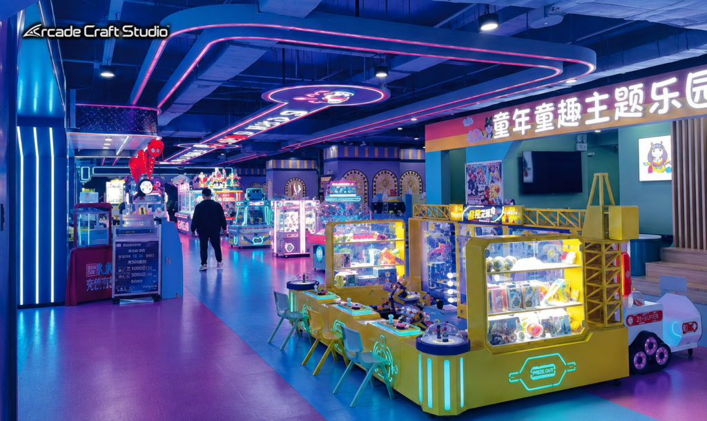 Shopping-mall kids' theme-park zone with crane claw machines, a prize-redemption counter and children's game cabinets under neon lighting